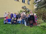 3.b klase zoodarzā pie dinozaura stajuas kopbilde ar audzinātāju
